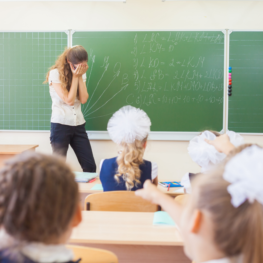stressed teacher standing in front of blackboard